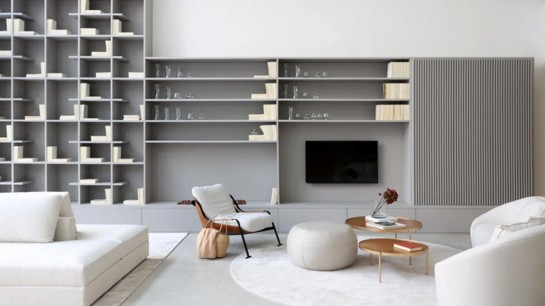 No projeto assinado pela arquiteta Ticiane Lima na Criare Perdizes, o destaque é a estante alta; o ambiente conta ainda com um armário com portas ripadas, painel e gaveteiros inferiores. Foto: Marco Antonio